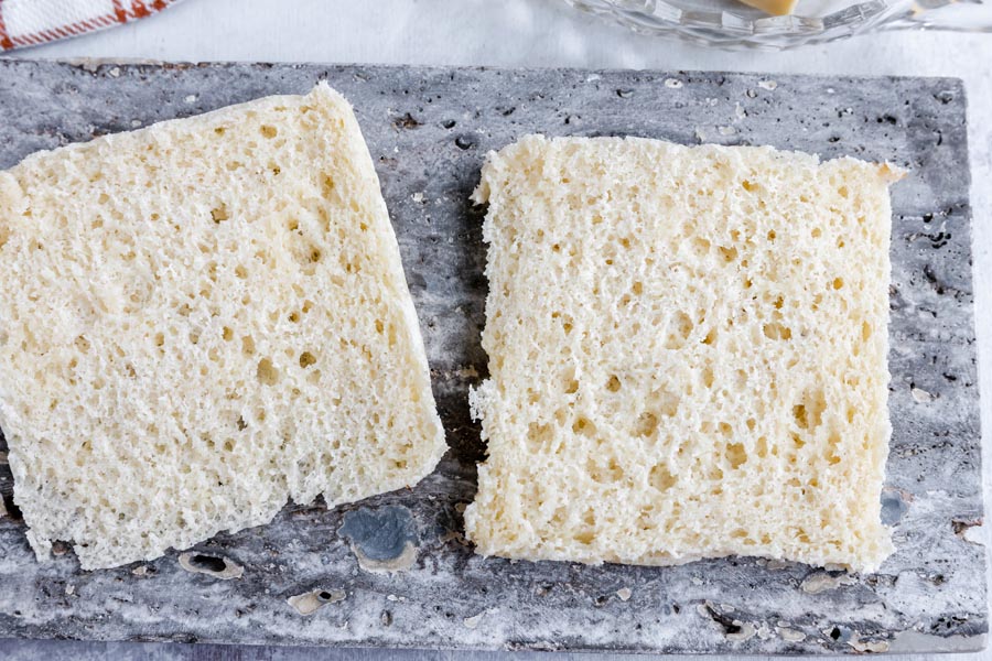 two slices of white bread on a gray slate tile