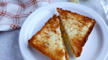 toasted bread on a plate with a checker napkin near