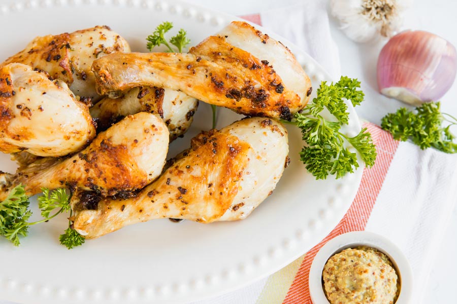 a bunch of fried chicken on a plate with mustard and parsley