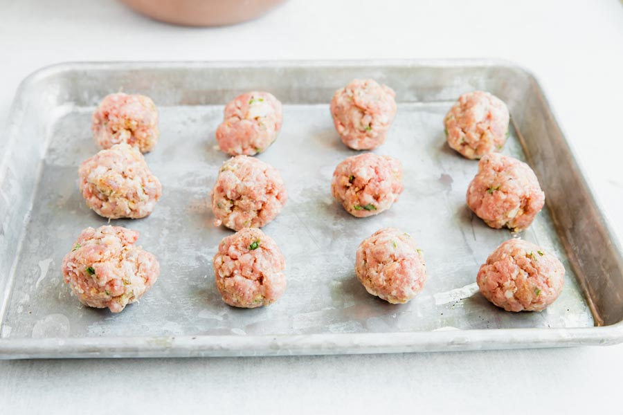 rolled out meatballs on a tray