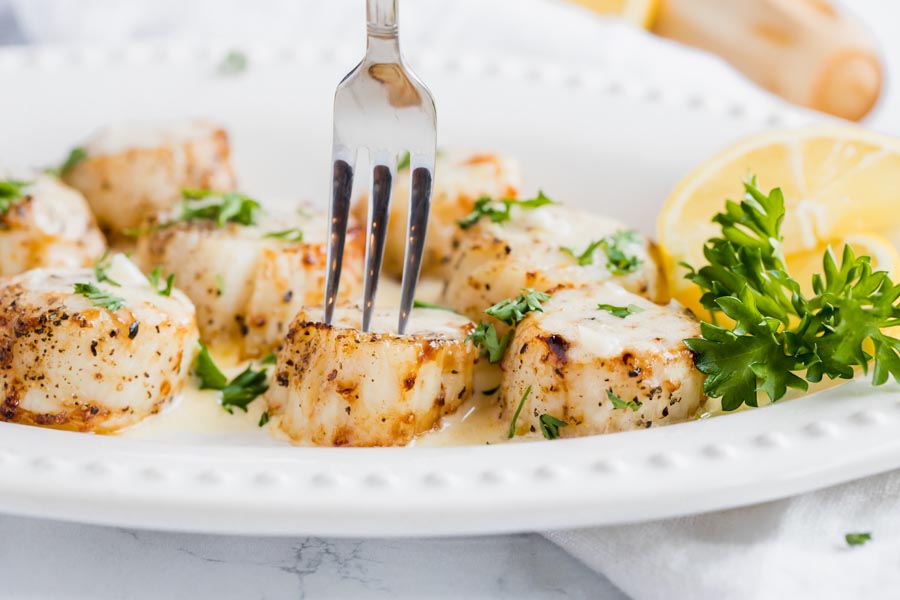 stabbing an scallop with a fork