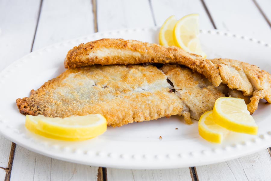 chunks of codrock fillets pan fried in almond flour on a white plate