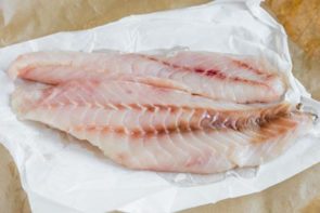 two raw rockfish fillets on parchment paper