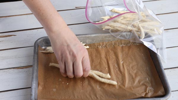 frozen french fries being shoved in a freezer bag