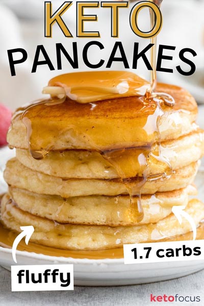 Fluffy pancakes on a plate with syrup drizzling down.