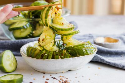 holding a string up cucumber ribbons with chopsticks