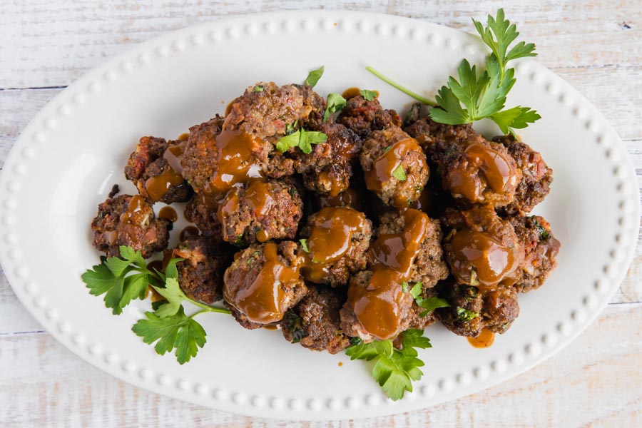 overhead view of saucy meatballs on a cocktail serving plate