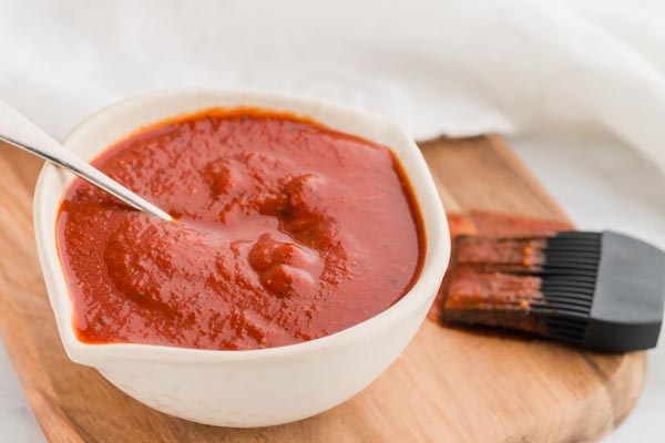 keto bbq sauce in a small bowl with a basting brush near