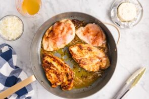 Seasoned chicken searing in a skillet.