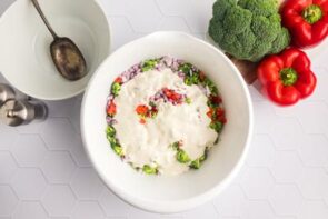 Creamy salad dressing covering a chopped salad in a serving bowl.