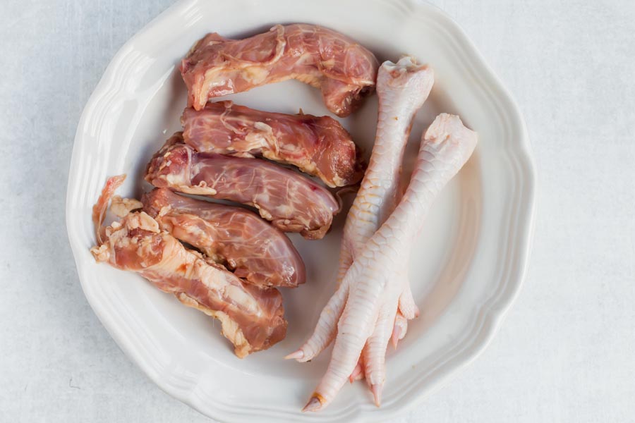 plate of chicken feet and chicken necks for bone broth