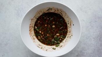 A bowl with a red marinade inside.