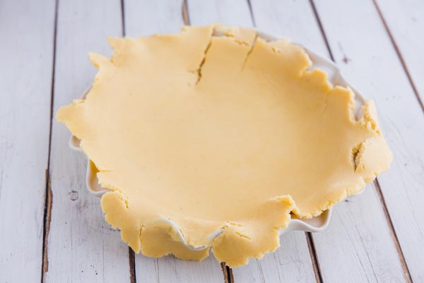 pie crust dough laying on a pie pan