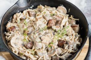 a skillet with a beef and noodle meal inside