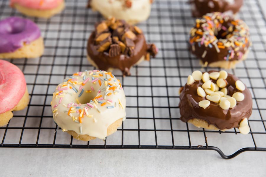 white chocolate and dark chocolate glazed donuts on a rack