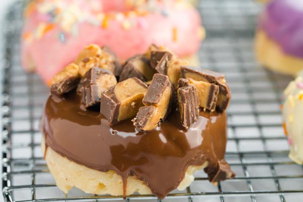 peanut butter cups on a chocolate glazed donut on a wire rack