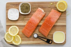 sprinkling black pepper on a salmon fillet