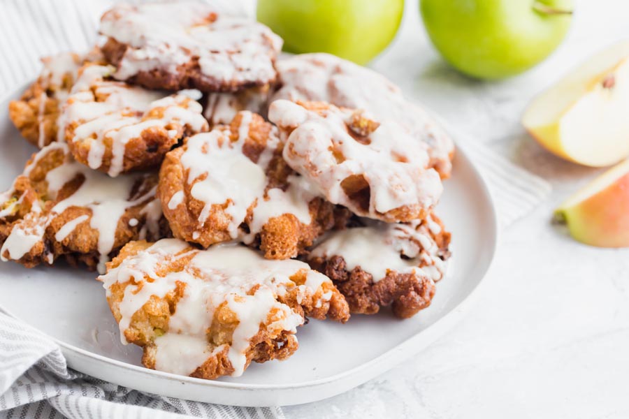 a breakfast plate with apple fritters and whole granny smith apples