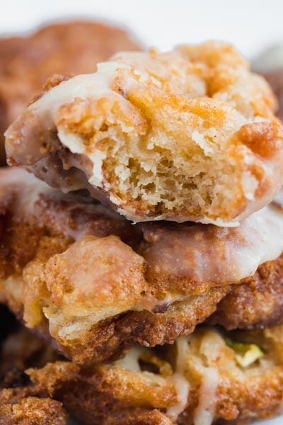 A bite taken out of an apple fritter showing the donut center.