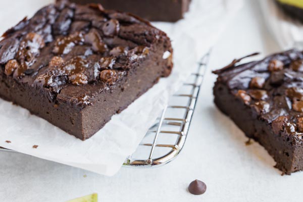 two big chocolaty avocado brownies topped with sugar free chocolate chips