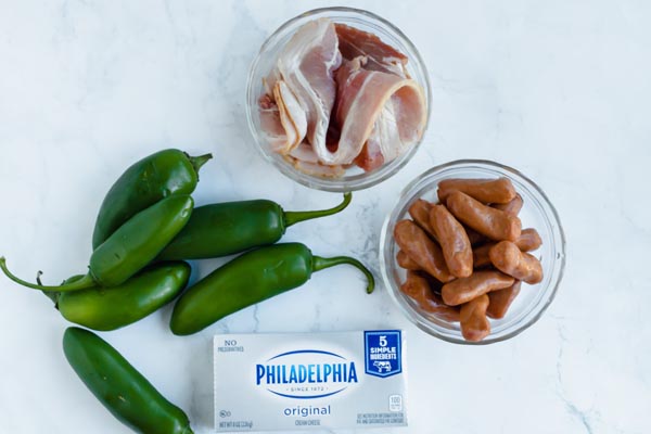 cream cheese, jalapenos, cocktail sausages and bacon on the counter