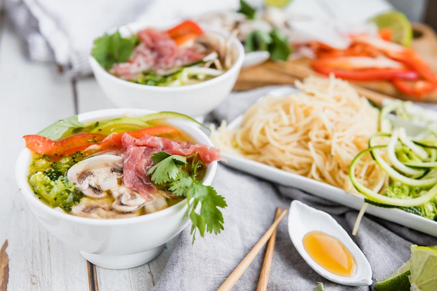 fresh pho broth loaded with thinly sliced vegetables and beef