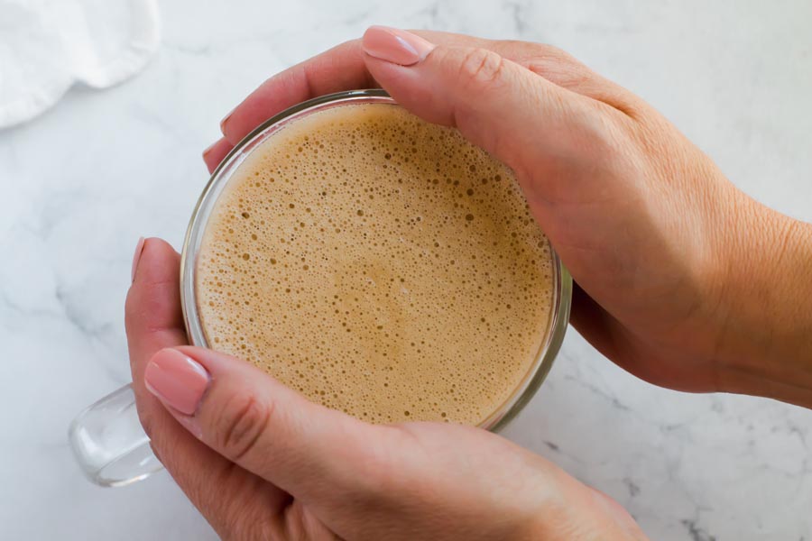 hands on mug of keto bulletproof coffee