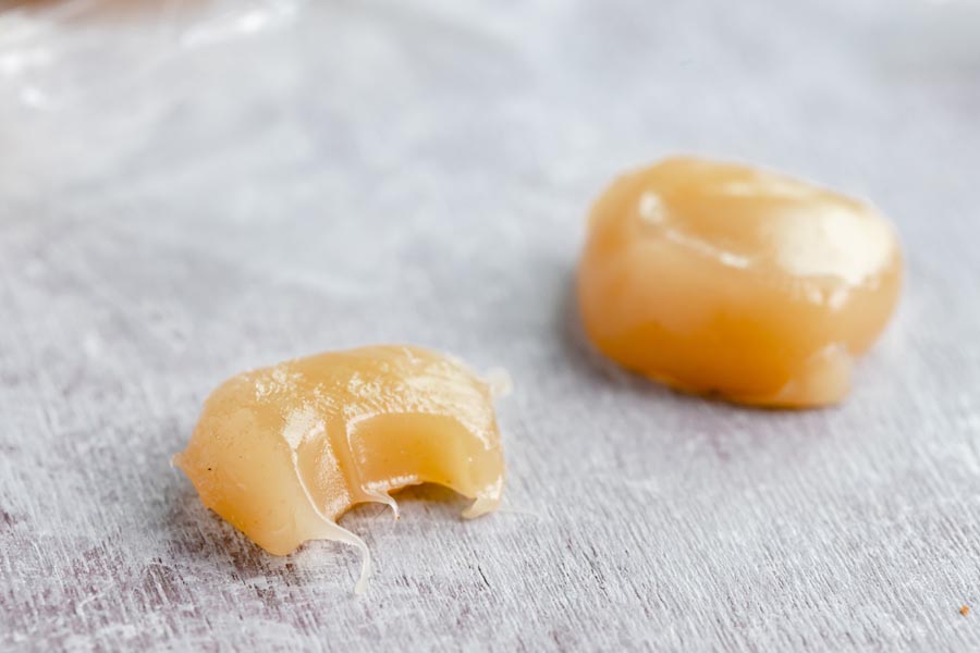 half bitten caramel next to a whole caramel chew