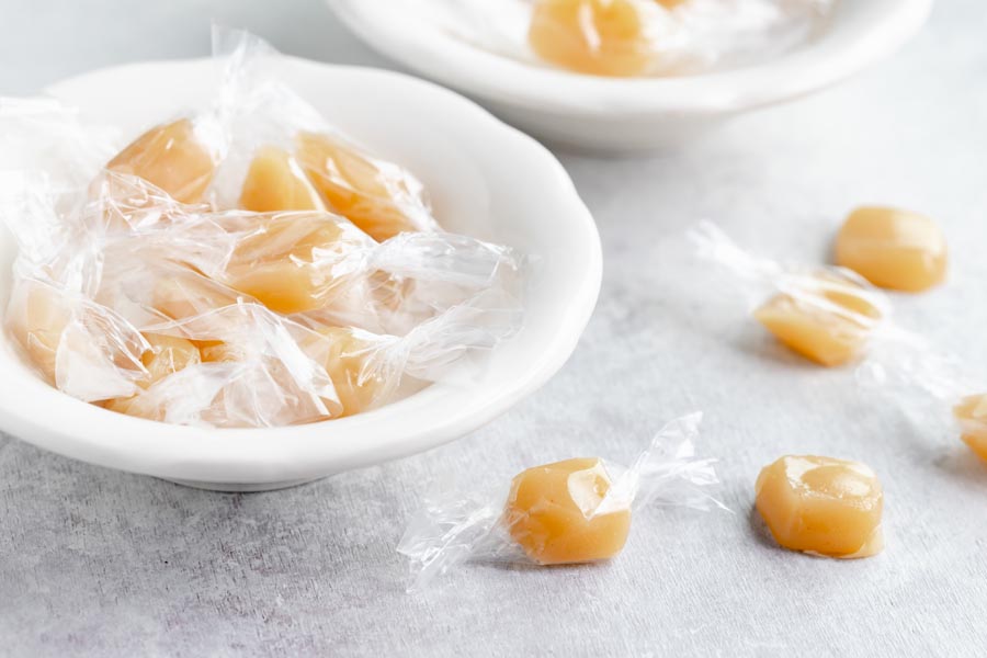 a bunch of wrapped caramels in a bowl