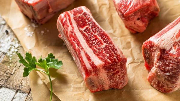 english cut short ribs on a wooden cutting board with parsley near