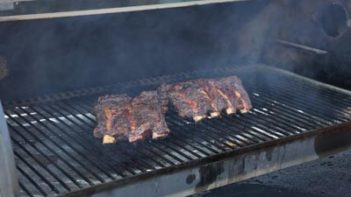 spraying beef ribs with a bone broth and apple cider vinegar mixture while they are cooking