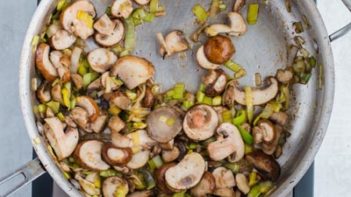 mushrooms and leeks cooking in a skillet