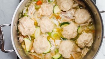 dumplings sitting in the chicken soup cooking