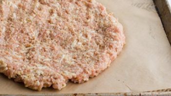 pizza chicken crust pressed onto a parchment lined baking tray