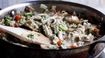 a skillet with chicken pot pie filling cooking inside