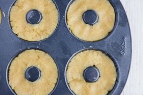 donut dough pressed into a donut pan