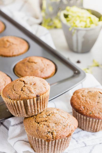 two muffins stacked on each other with a muffins in a muffin tin in the background