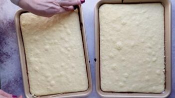 Hands pulling out baked sheet cakes from the pan.