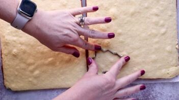 Punching out tree shaped cakes with a tree cookie cutter.