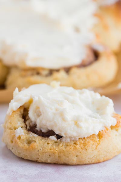 A cinnamon roll topped with cream cheese frosting.