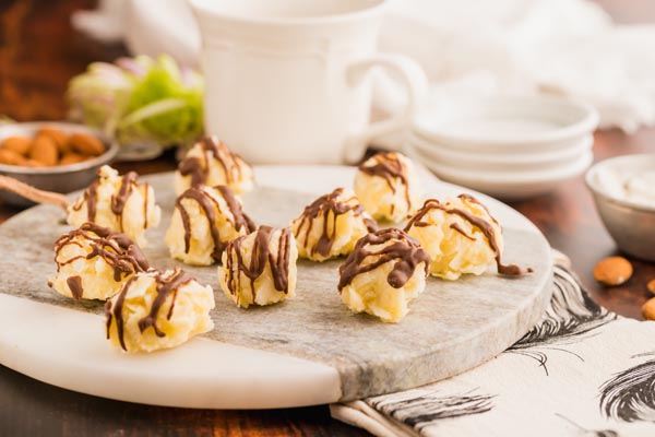 a tray with coconut candies on them with plates and a coffee in the background