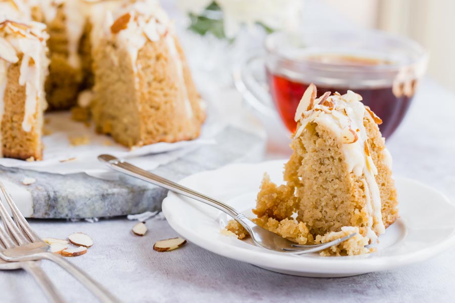 a slice of coffee cake with a black coffee in the background