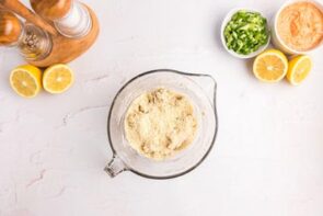 Almond flour sitting on top of crab meat in a measuring cup.