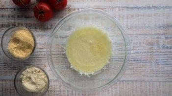 melted mozzarella cheese in a glass bowl next to two keto flours and tomatoes