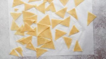 a bunch of triangle cut dough on parchment