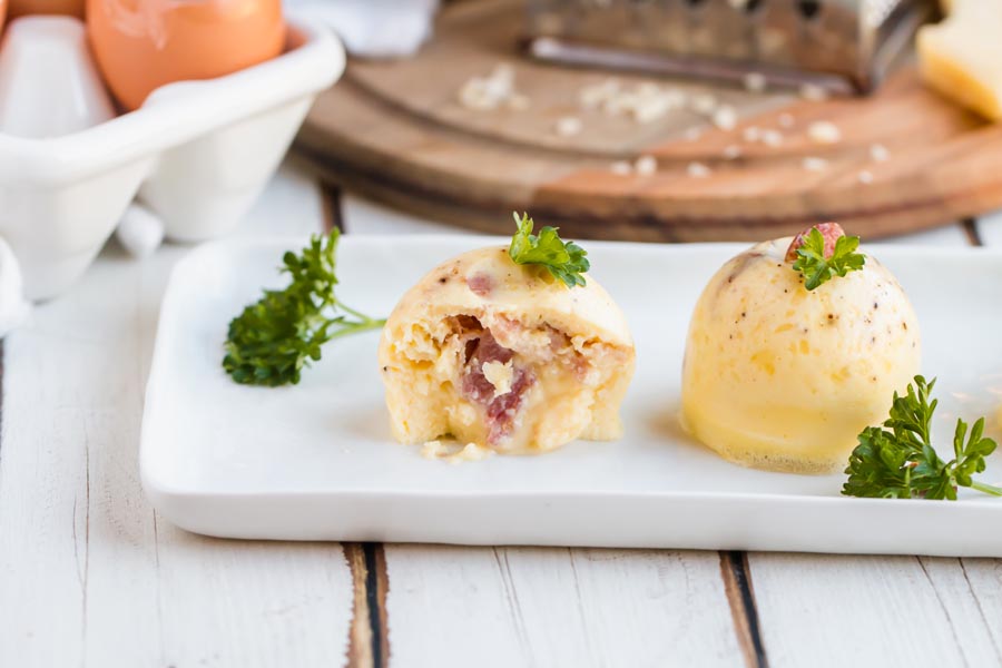 three egg bites on a rectangle white plate with one halfway eaten