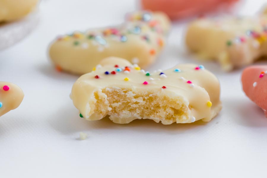 a bite taken out of a white frosted animal cookie