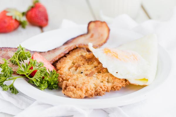 eggs and bacon served over a hash brown patty