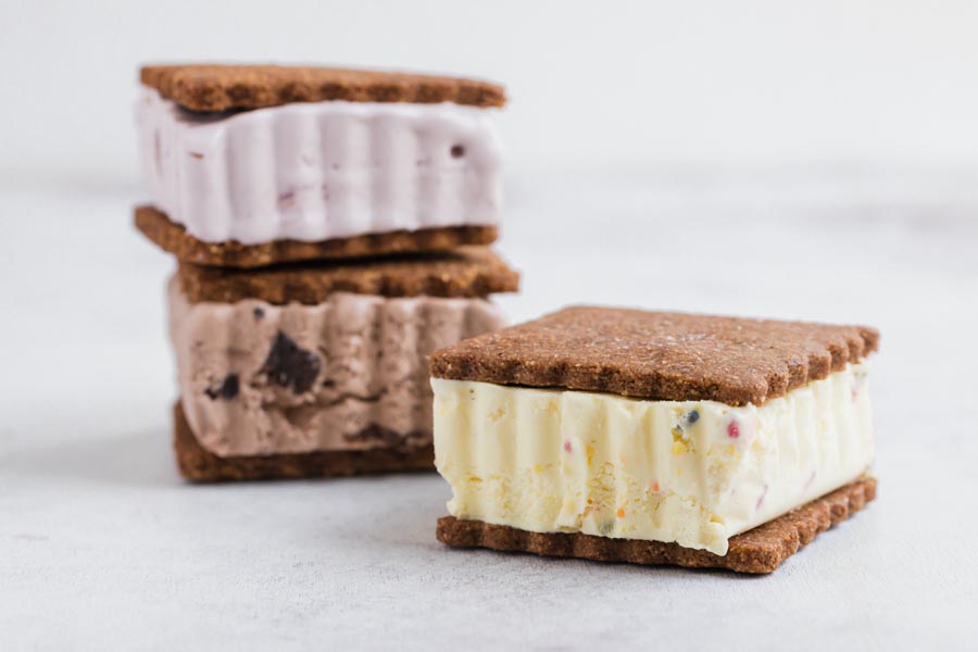 three ice cream sandwiches a vanilla, chocolate and raspberry