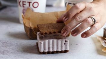 placing the top chocolate cookie on top of an ice cream sandwich